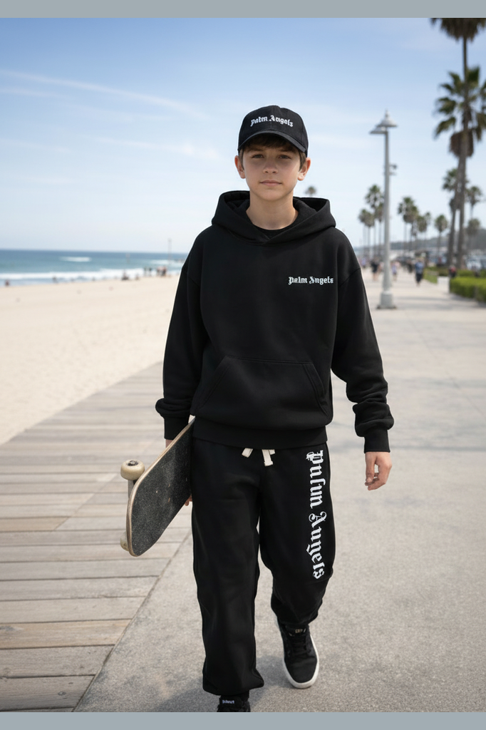 Person wearing Palm Angels hoodie and pants on a beach boardwalk