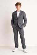 Person wearing a gray suit with a white shirt on a plain background