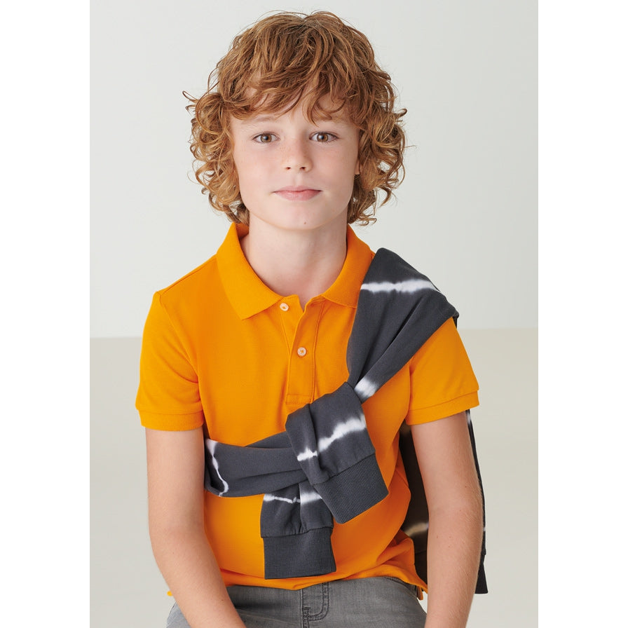 Boy wearing classic short sleeved orange Polo shirt. 100% Sustainable cotton